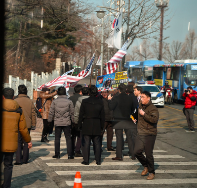 South Koreans hold American flags as they line up outside of the Seoul National Cemetery where Mattis is participating in a wreath laying ceremony. 